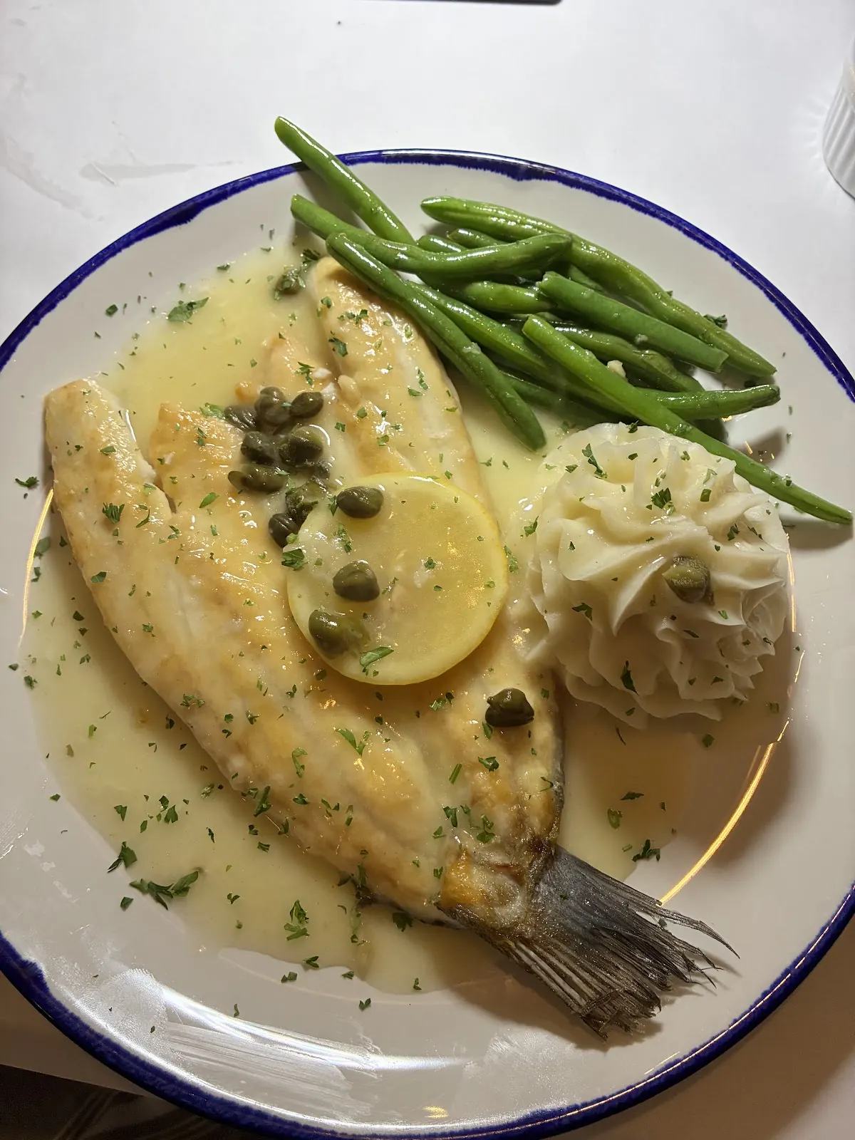Fish fillet with lemon and capers, green beans and mashed potatoes